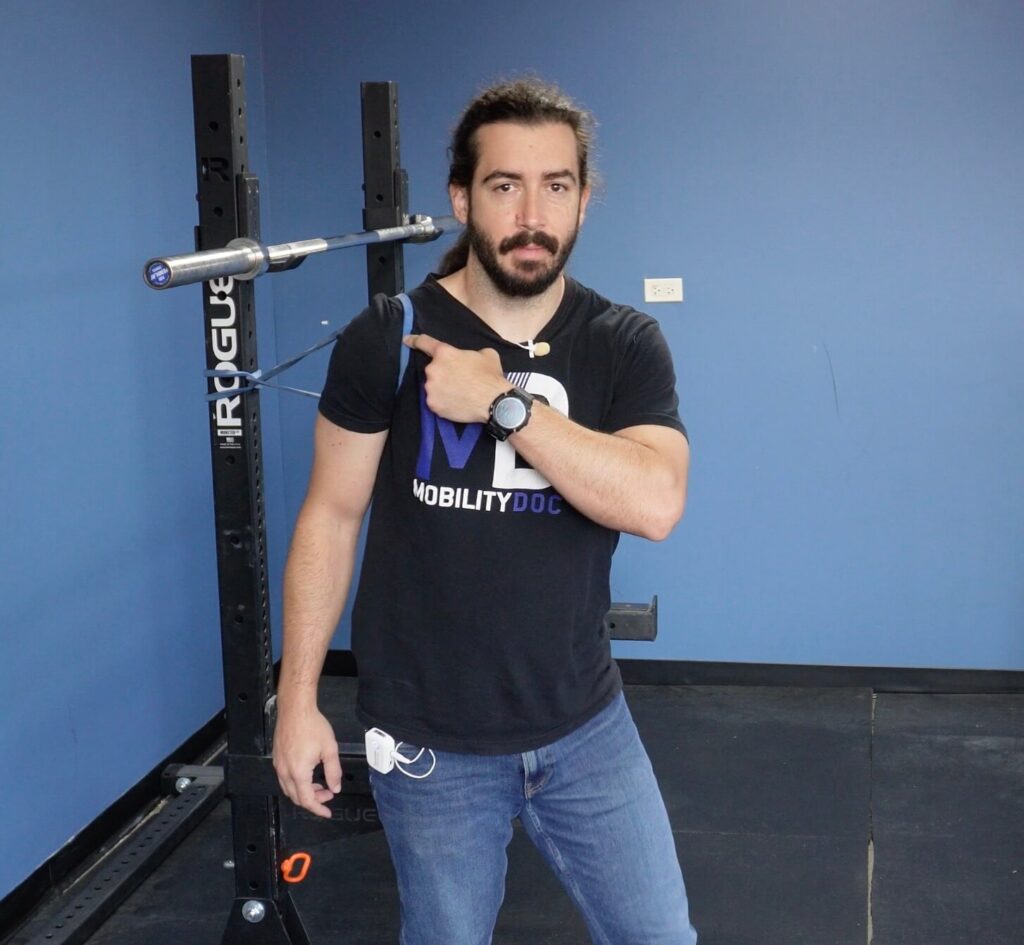 Dr. John demonstrating how to place the band on your shoulder for the banded shoulder mobility exercises